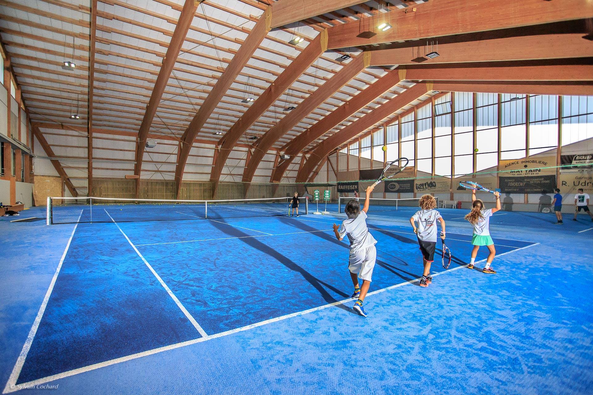Bild der Tennishalle des TC Morgins mit drei Kinder am Spielen